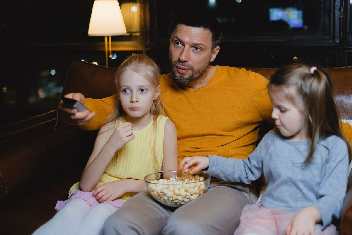 Familia viendo una película en el sofá frente al televisor del salón