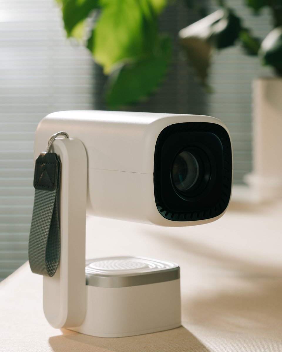 Mini proyector portátil compacto de color blanco con asa sobre una mesa