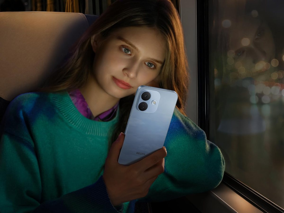 Chica haciéndose un selfie con un REDMI Note 17 Pro 5G azul junto a una ventana de noche